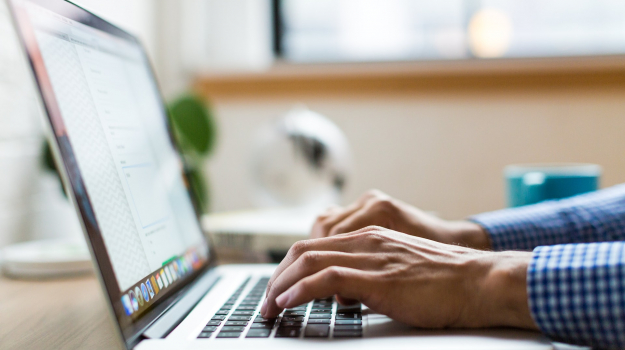 A person types on a laptop computer