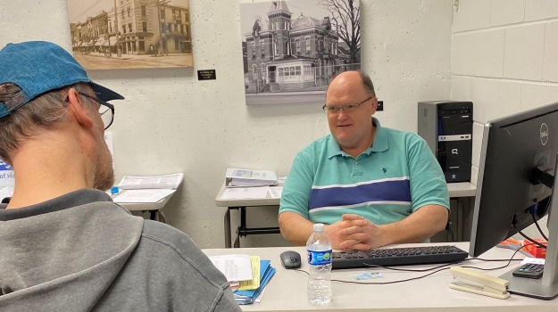 A VITA volunteer assists a client with his taxes